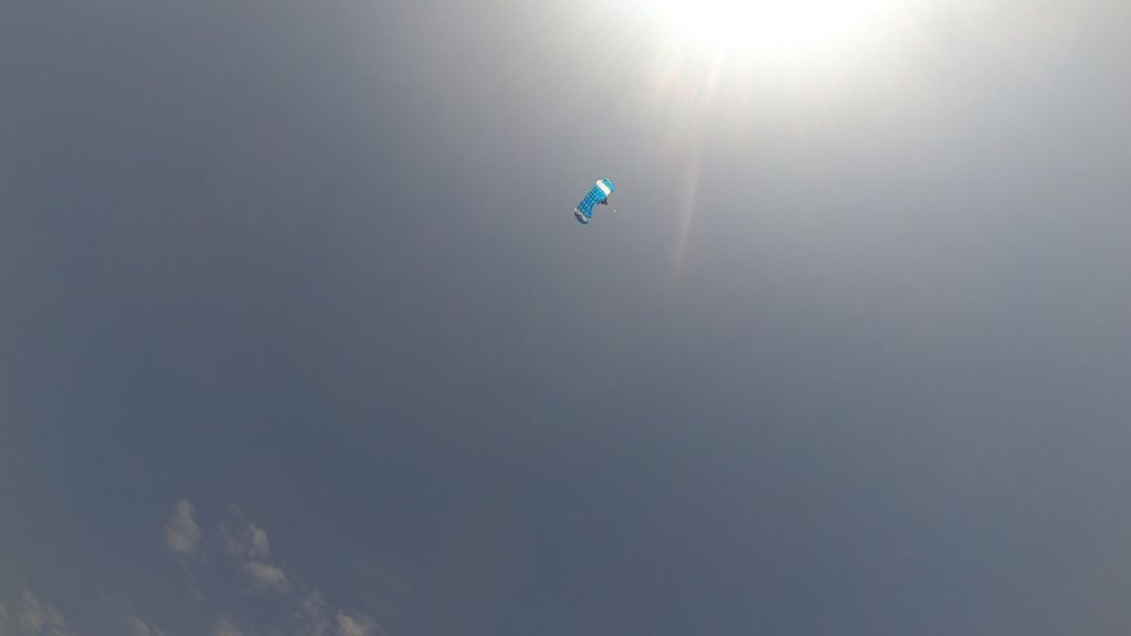 Matt's parachute is deployed - a small speck of blue in the vast sky