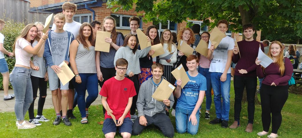 students brandishing their results envelopes