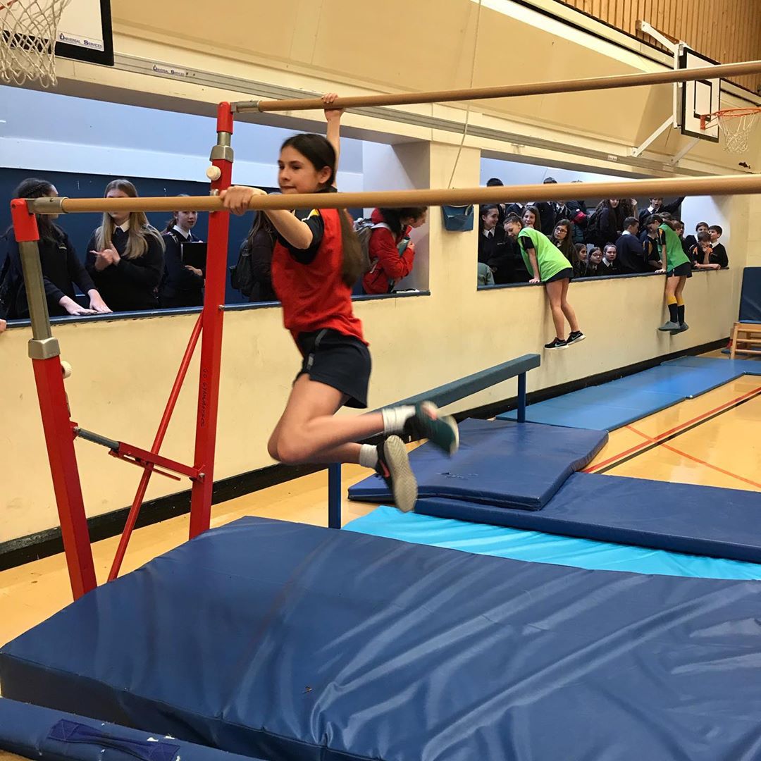Girl leaping between parallel bars.