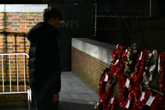 Student stood in front of memorial wreaths