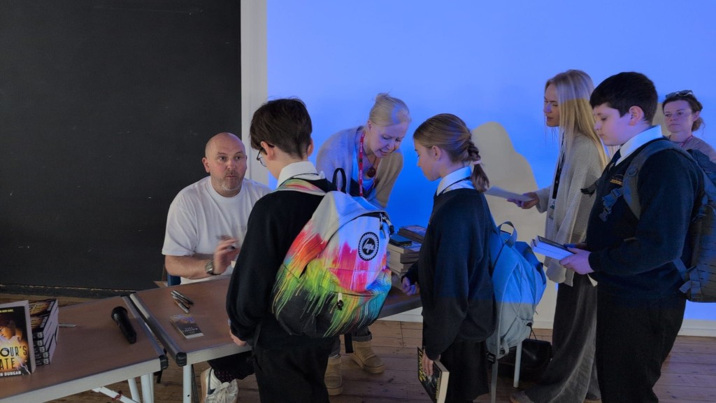 Brian Dungan signing books for Year 7 students
