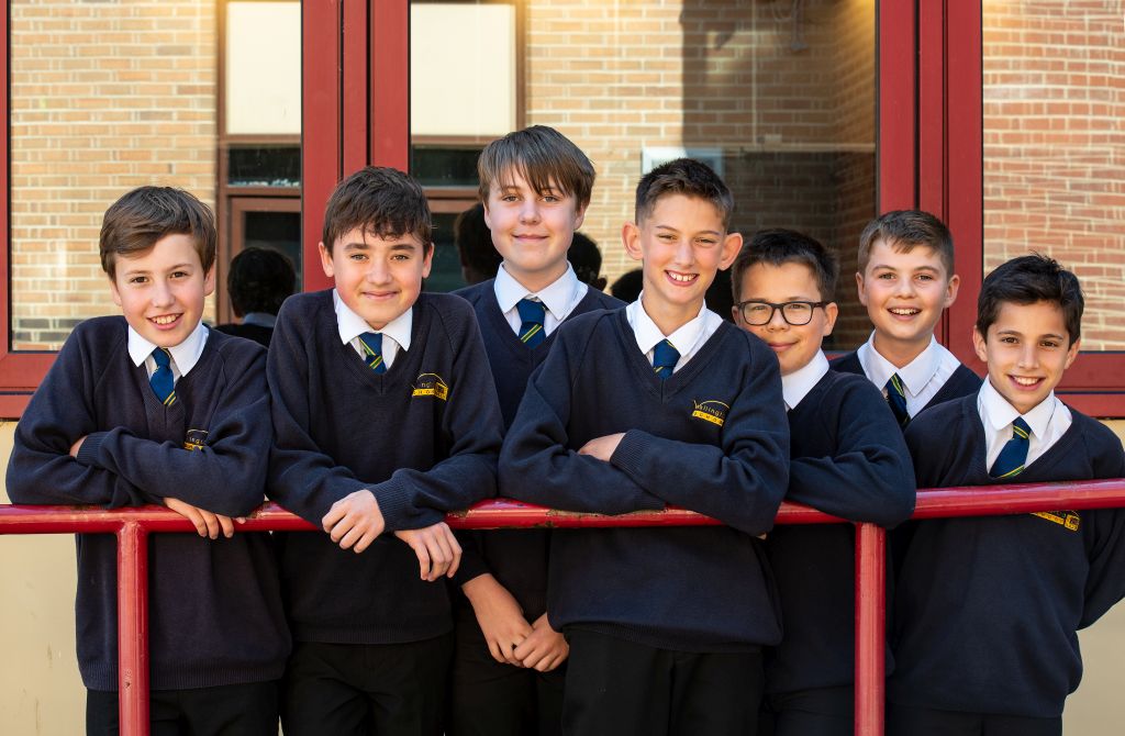 Group of boys standing in front of a school building