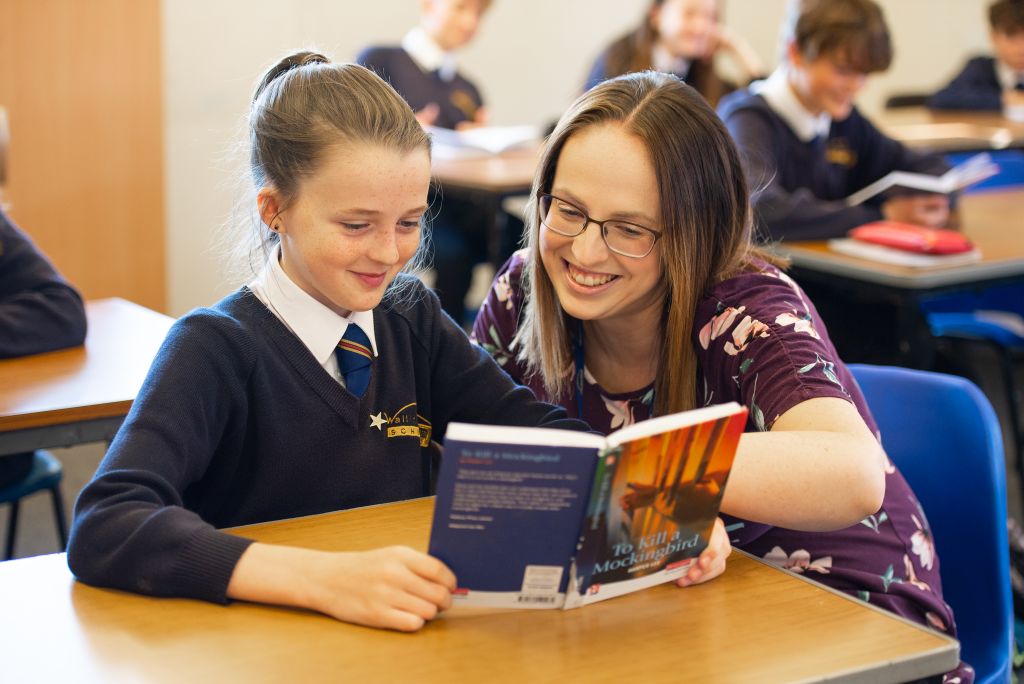 teacher and student reading "To Kill A Mockingbird"