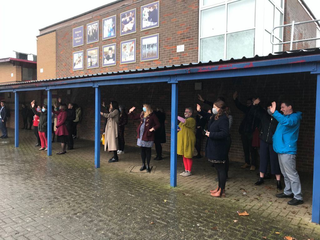 Staff wave from under shelter