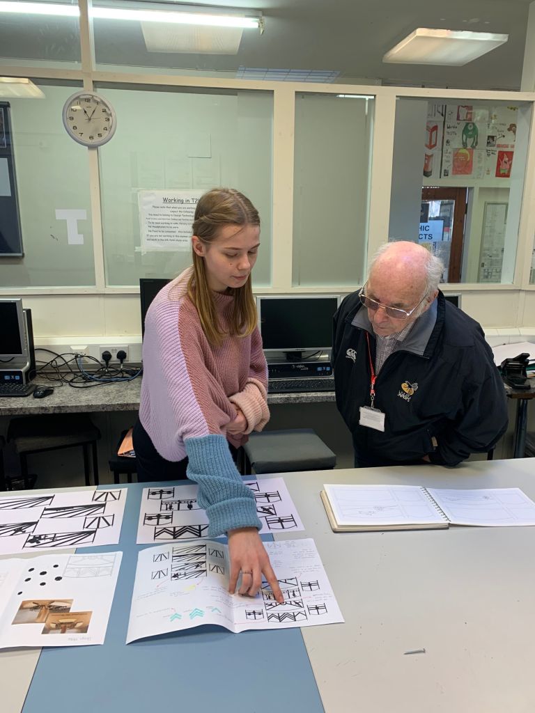 Student shows Mr Kidley her design.