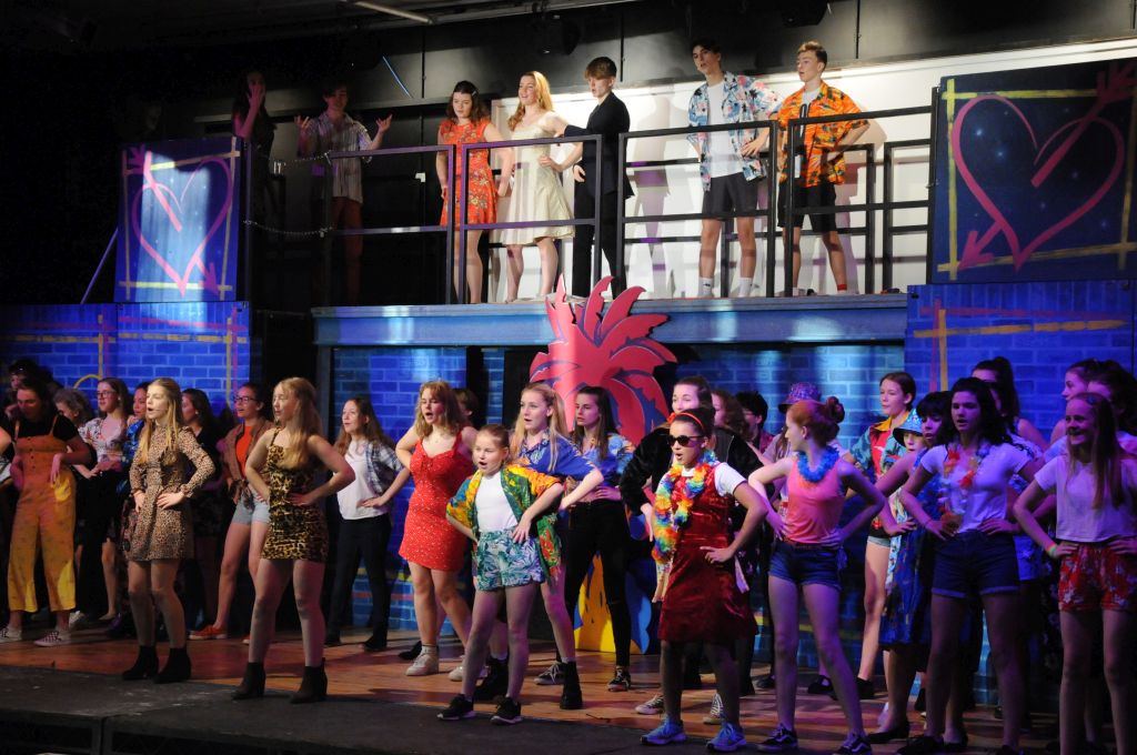 Large selection of cast during one of the musical numbers in Our House