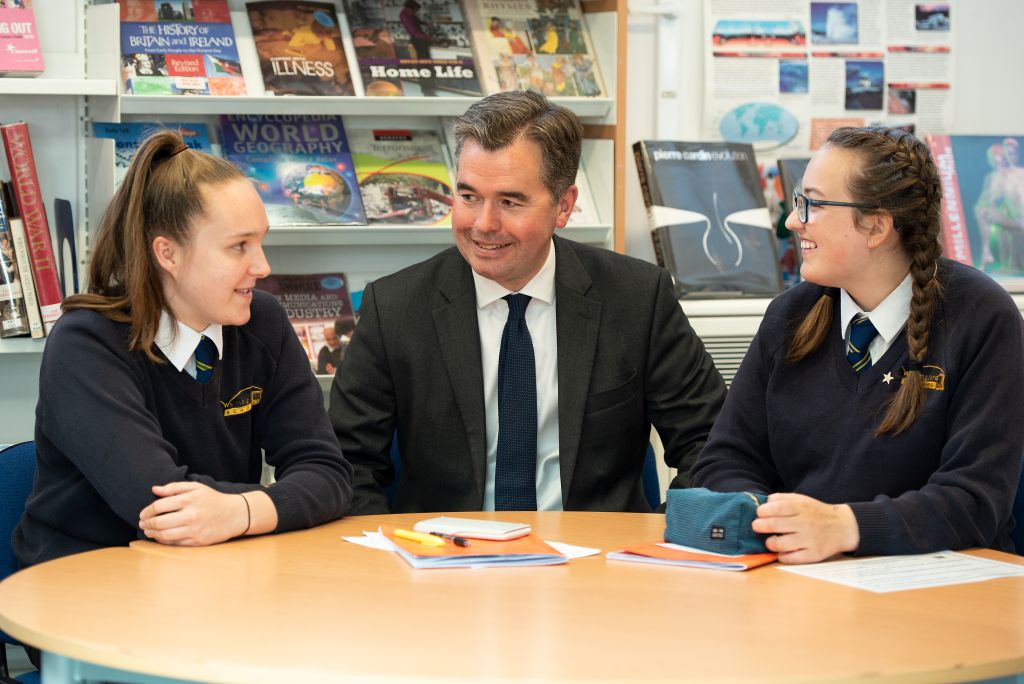 Mr Marston sat with two students in the school library